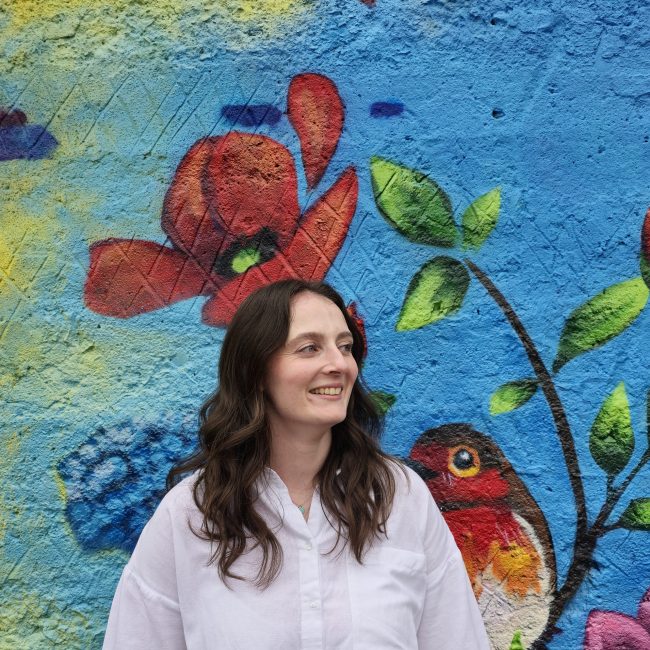 headshot of Brooke Quick with floral art background